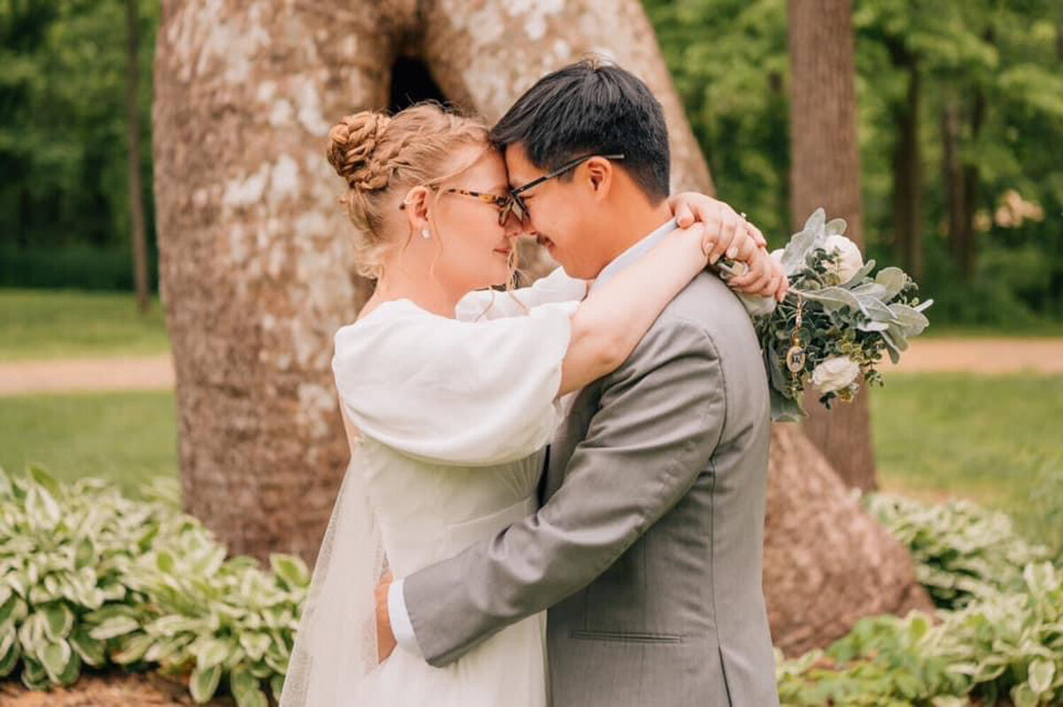 Bride and groom hugging and about to kiss in front of sycamore tree