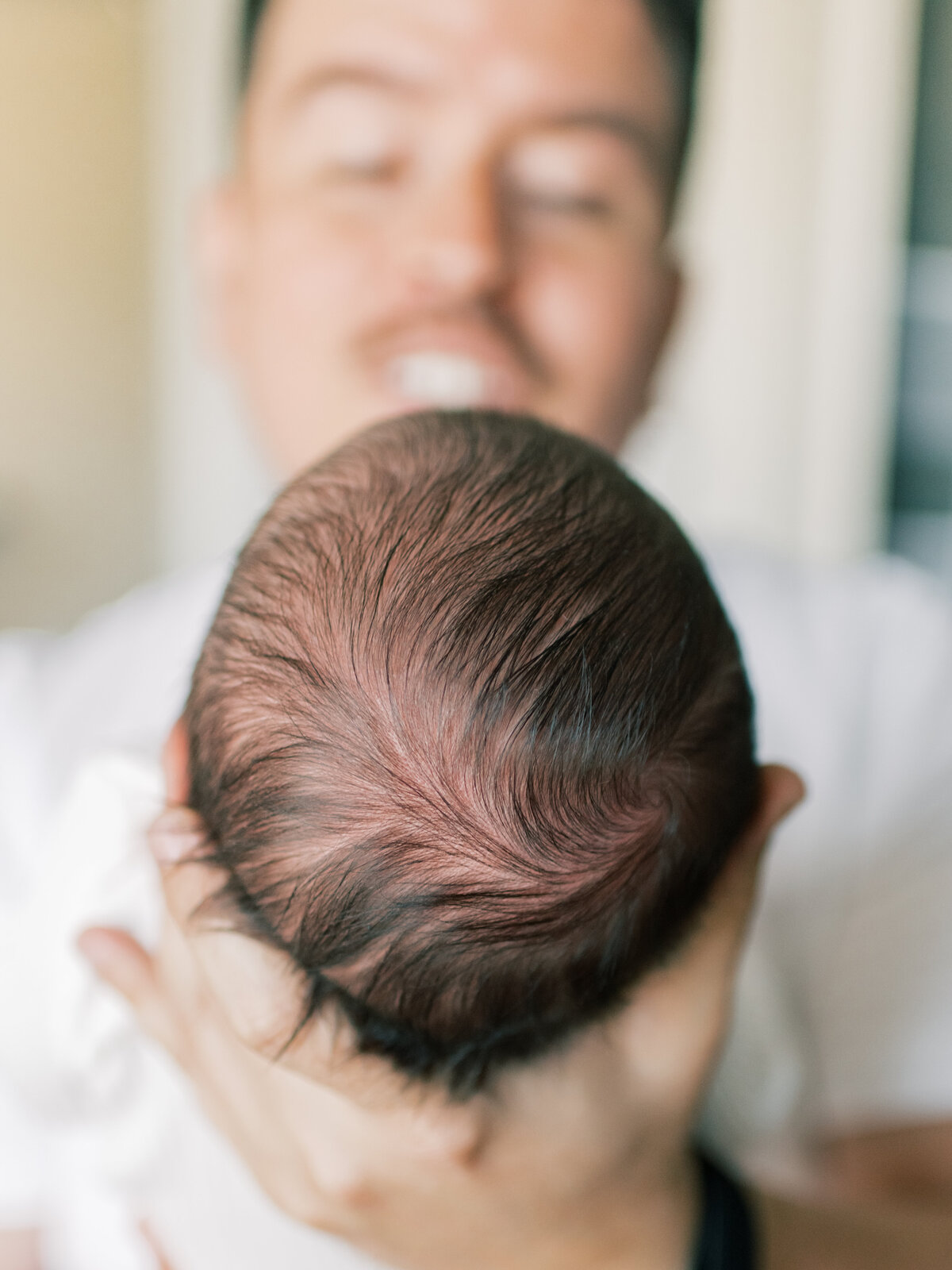 Close up photo of newborn baby boys brown hair.