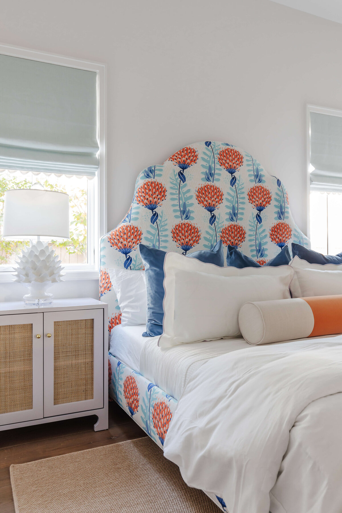 oyster creek studios memorial new build orange and bright blue bedframe white bedspread in bedroom