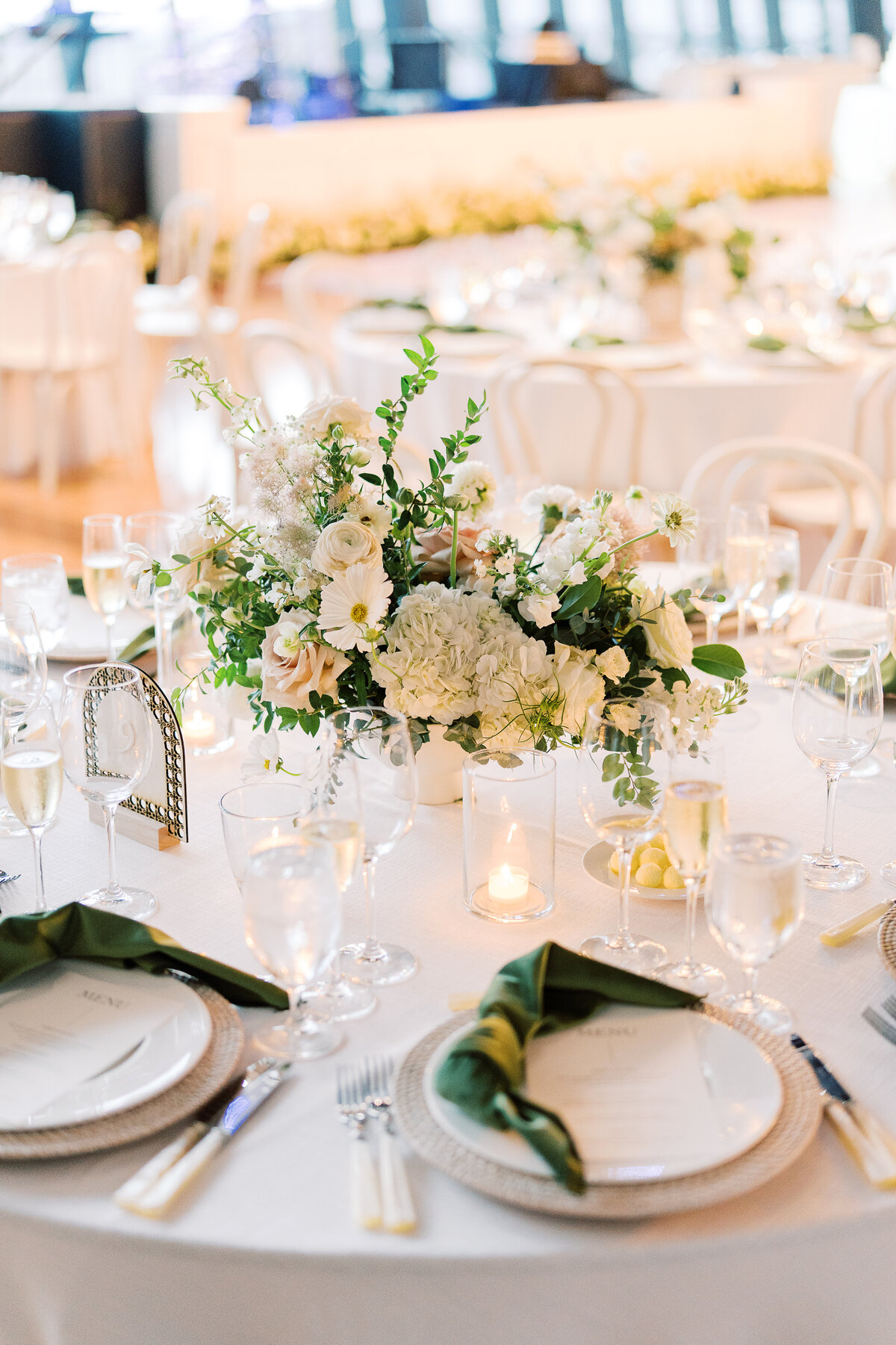 Lush low centerpieces for timeless garden wedding in downtown Nashville. Summer wedding florals in colors of white, cream, green, and taupe. Summer floral design full of roses, ranunculus, hydrangea, cosmos, and lisianthis. Design by Rosemary & Finch Floral Design in Nashville, TN.