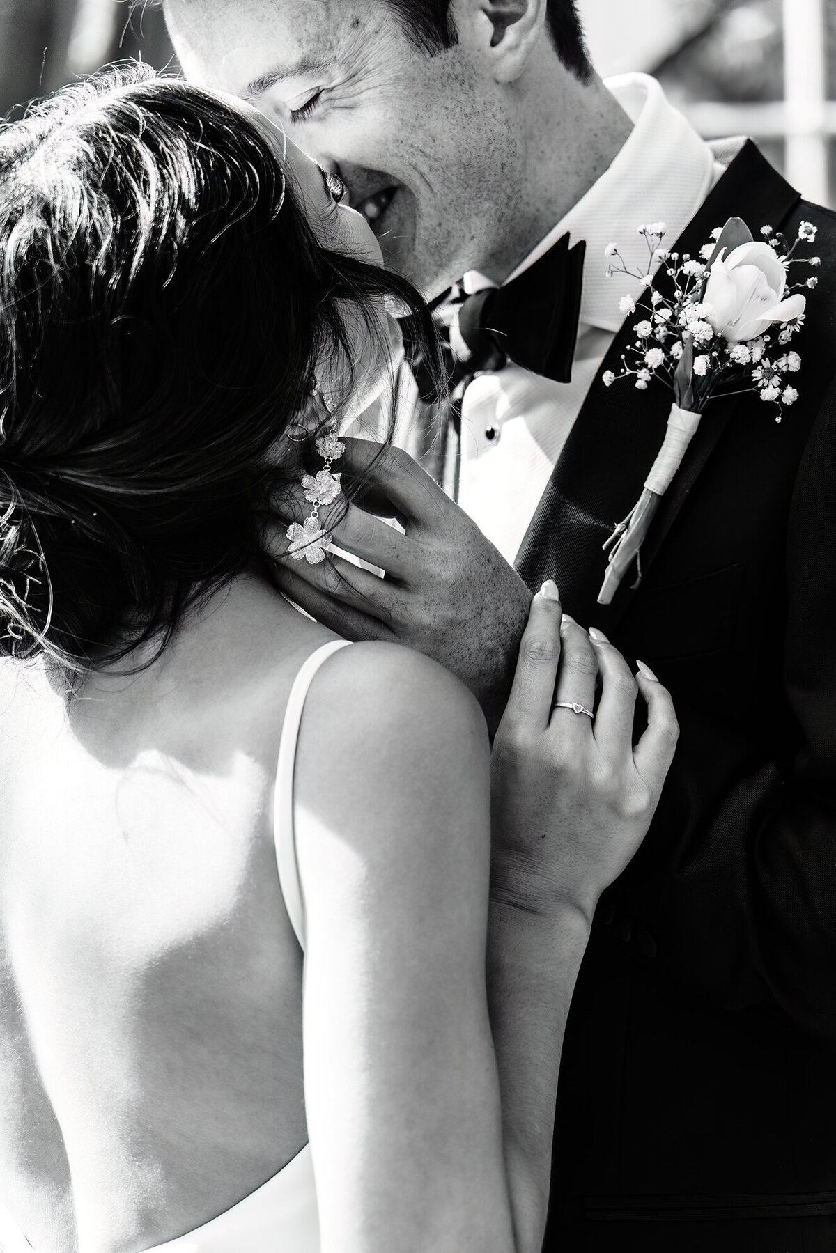 a bride in front of her goom in an embrace smiling at each other