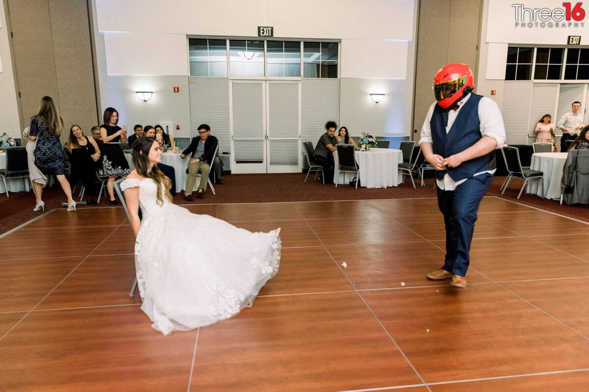 Wearing a motorcycle helmet the Groom is ready for the garter belt