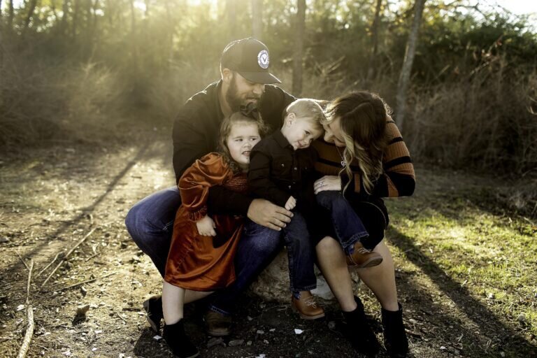 The family bonding over a game, sharing smiles and giggles in a fun-filled photoshoot experience