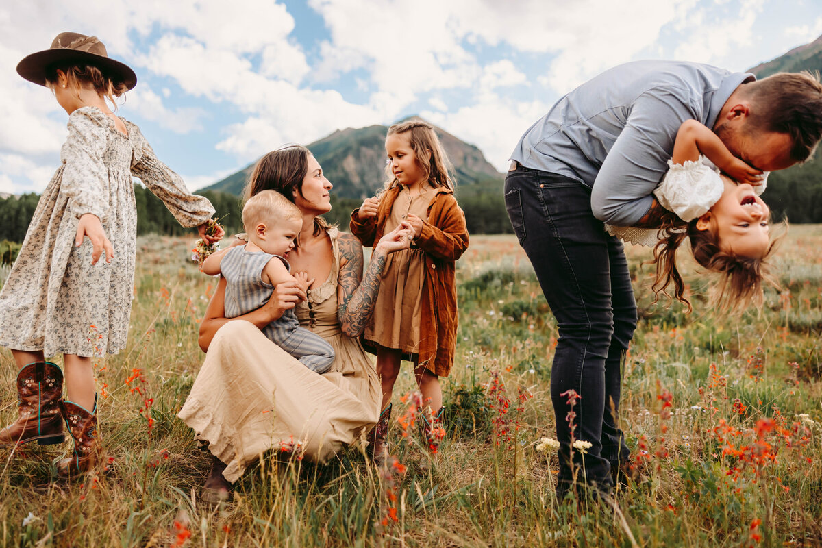 Family plays in field of wildflowers in Telluride.