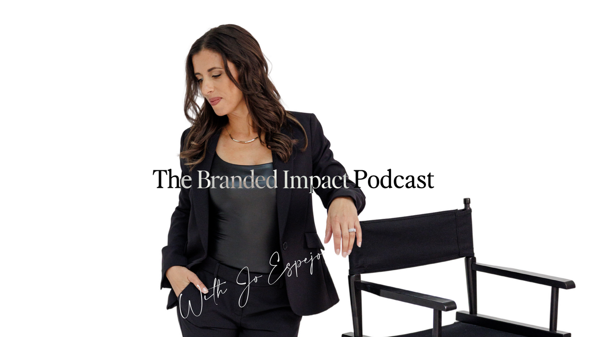 Jo Espejo host of the branded impact podcast and branding expert  looking to the side at floor while standing and leaning against a director’s chair, 
