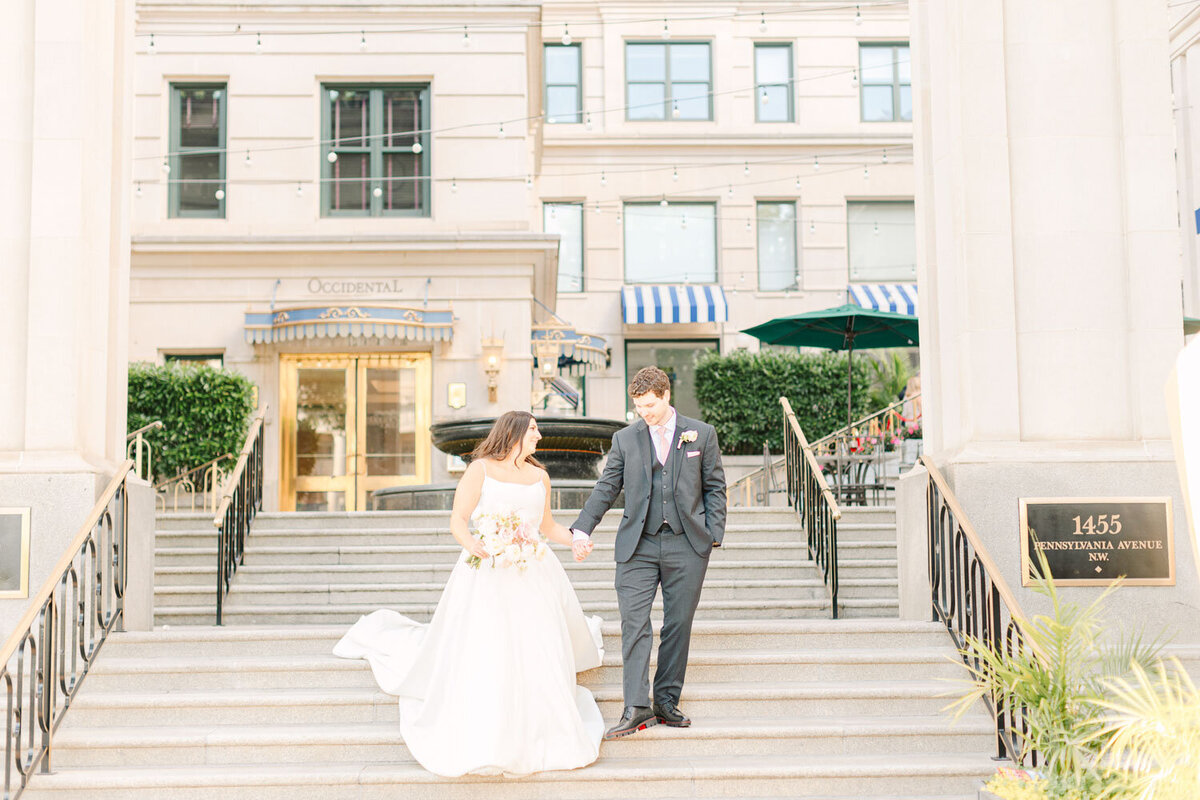 Bride and groom holding hands while walking outdoors
