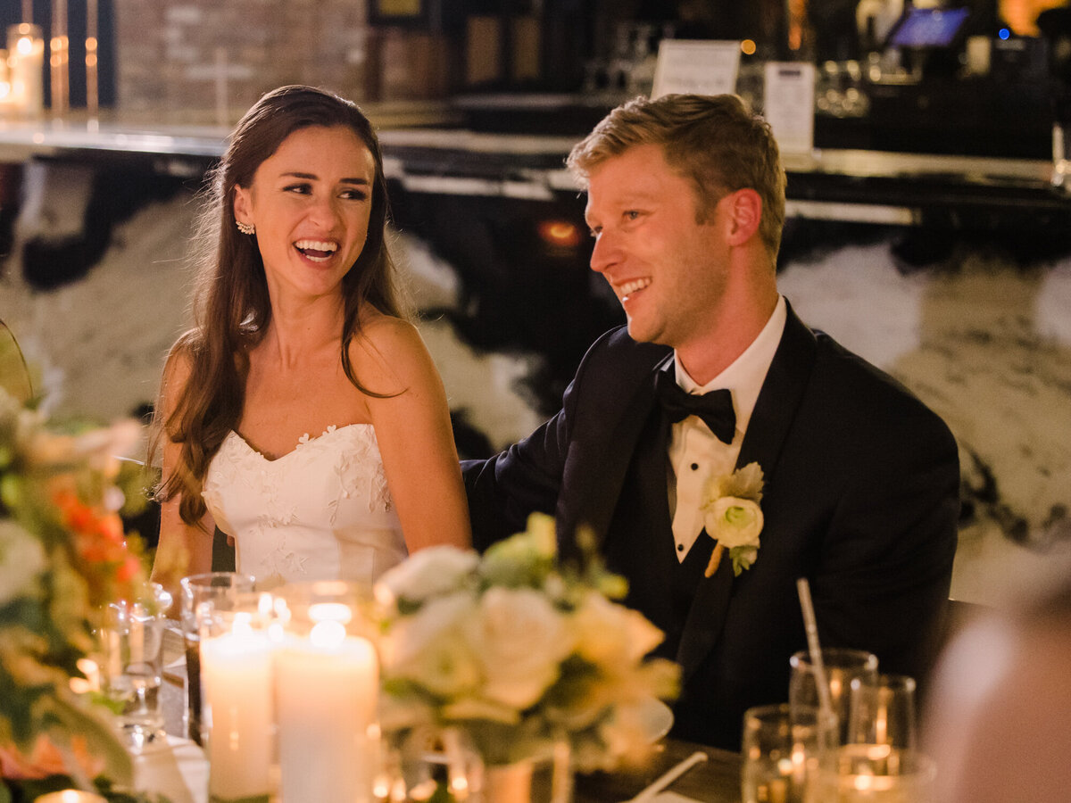 A bride and groom react to a heartfelt toast on their wedding day