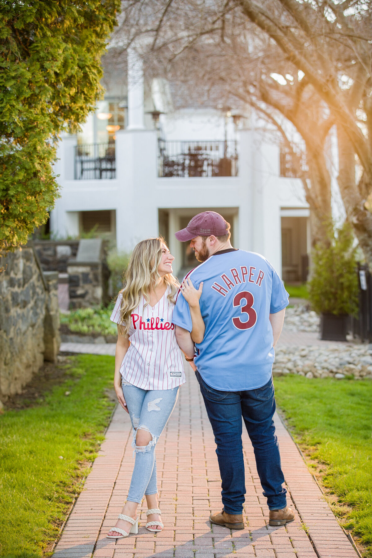 An engaged couple proudly celebrating their love for the Philadelphia Phillies by wearing jerseys during their engagement session, capturing their playful spirit and mutual passion for the hometown team.