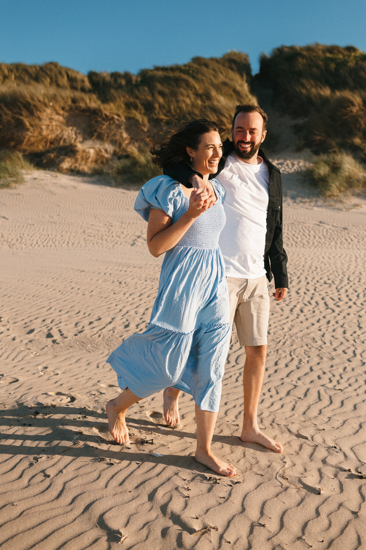 photo of a Couple walking on the beach 