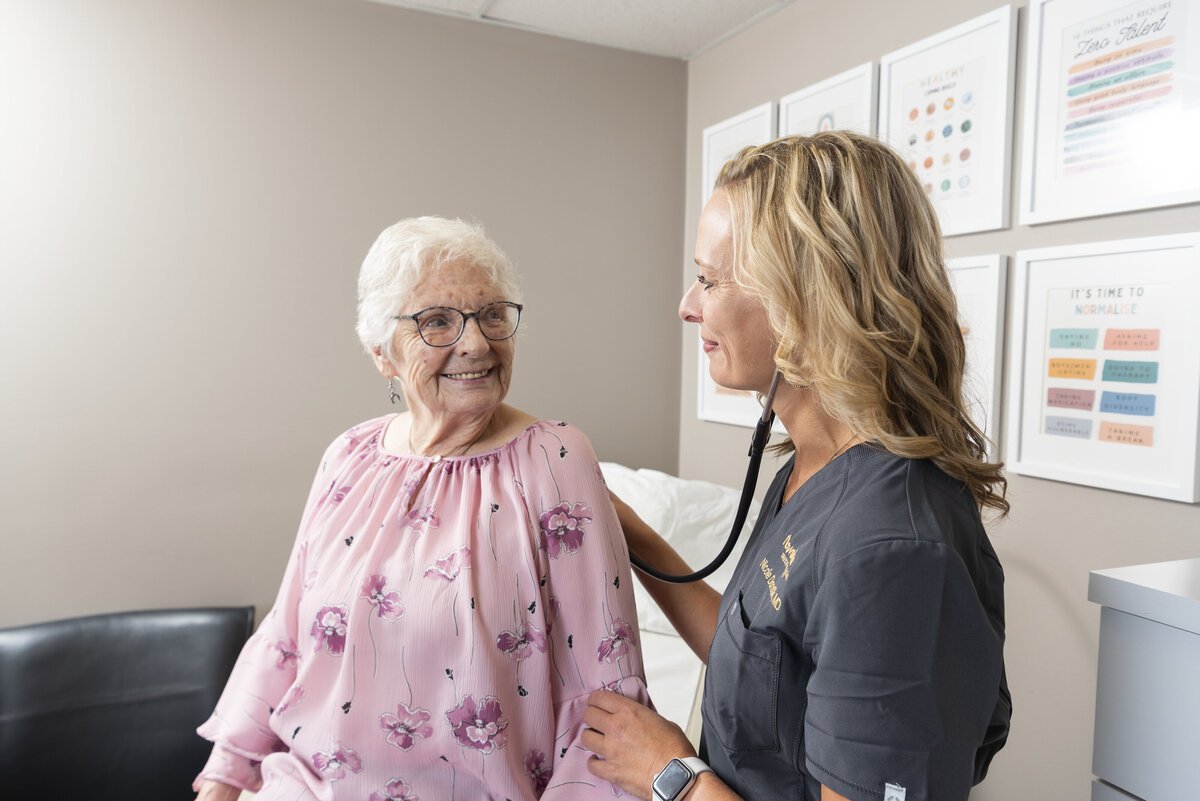 a doctor checking a woman's heart with a stethoscope