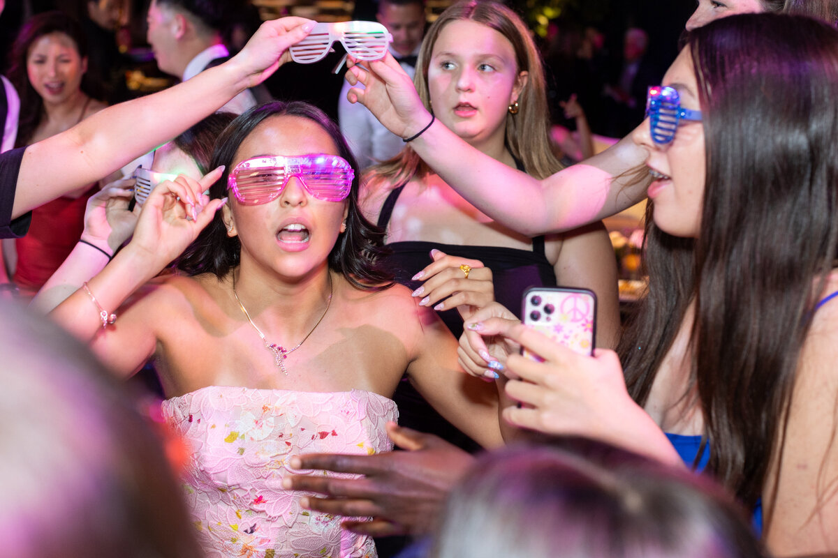 Girls in clear sunglasses dancing together