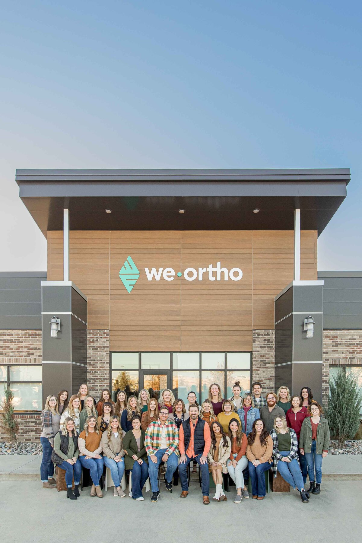 staff members in front of an orthodontist building