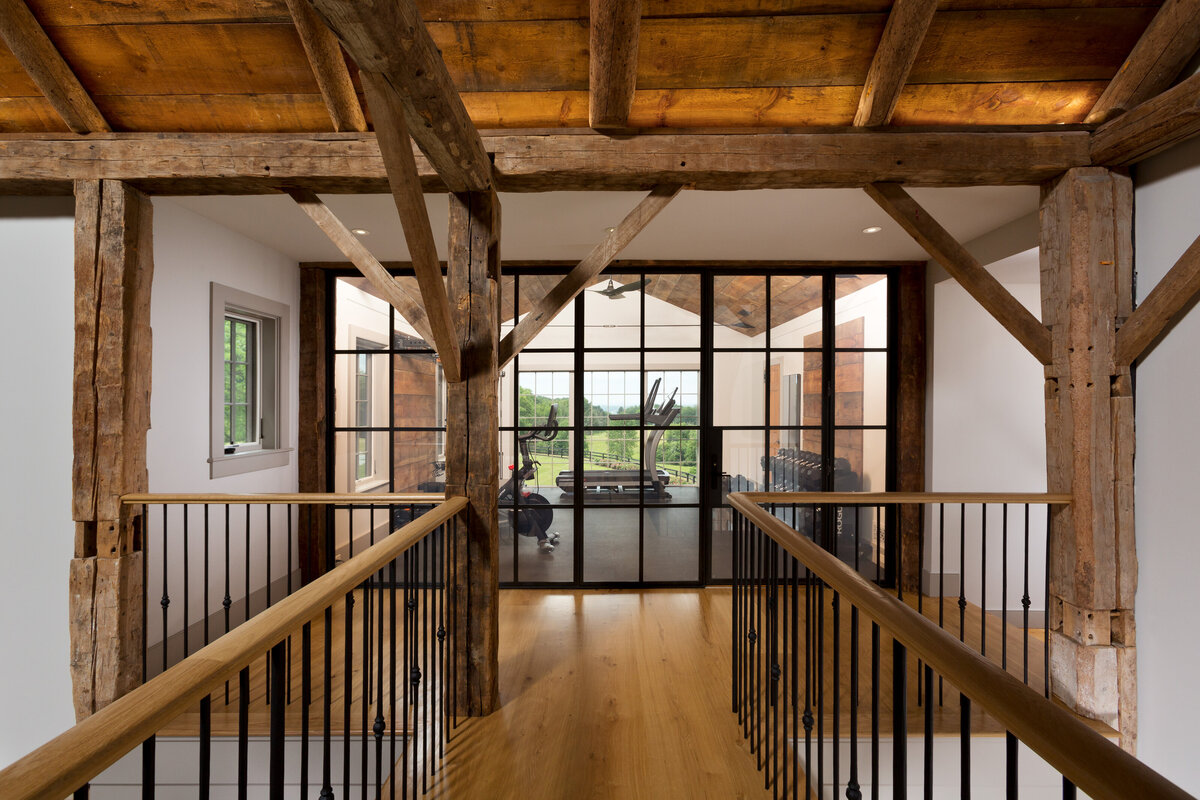wood  hallway with wall of windows over looking gym