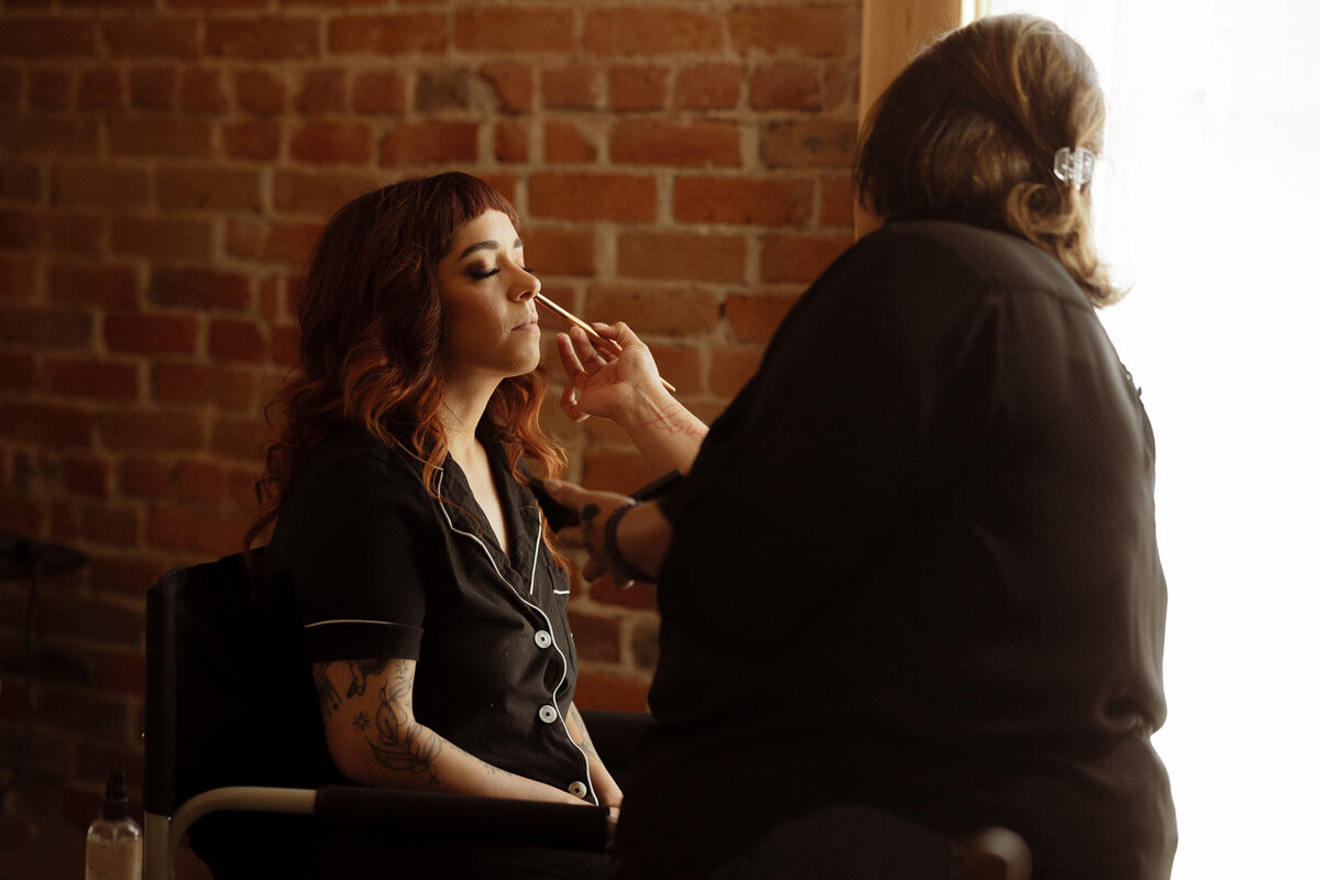 Bride gets her makeup done on her wedding day in Denver, Colorado.