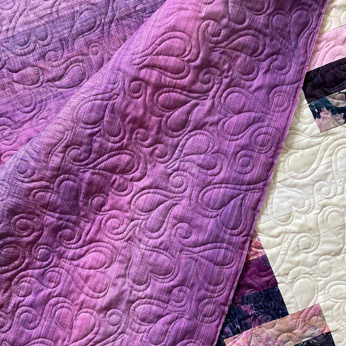 Whimsical hearts quilting design featured on a purple quilt back