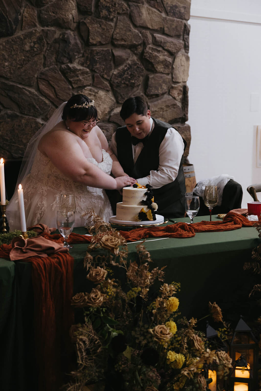 A wedding couple cuts their wedding cake at their fall wedding held at Sky Camp Oregon wedding venue.