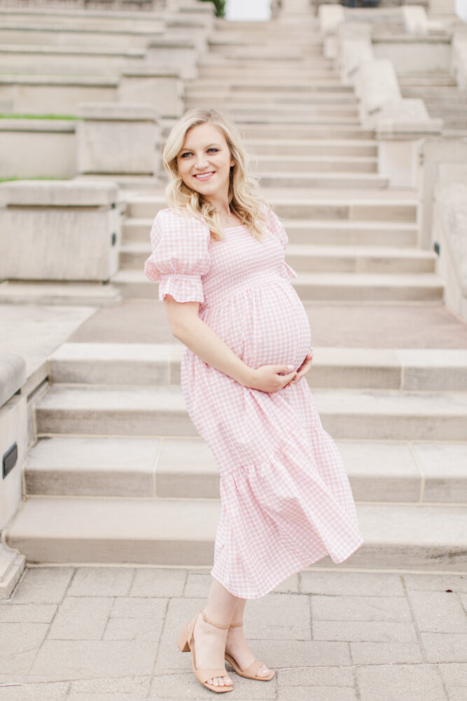 a pregnant woman smiling in a flowy pink dress
