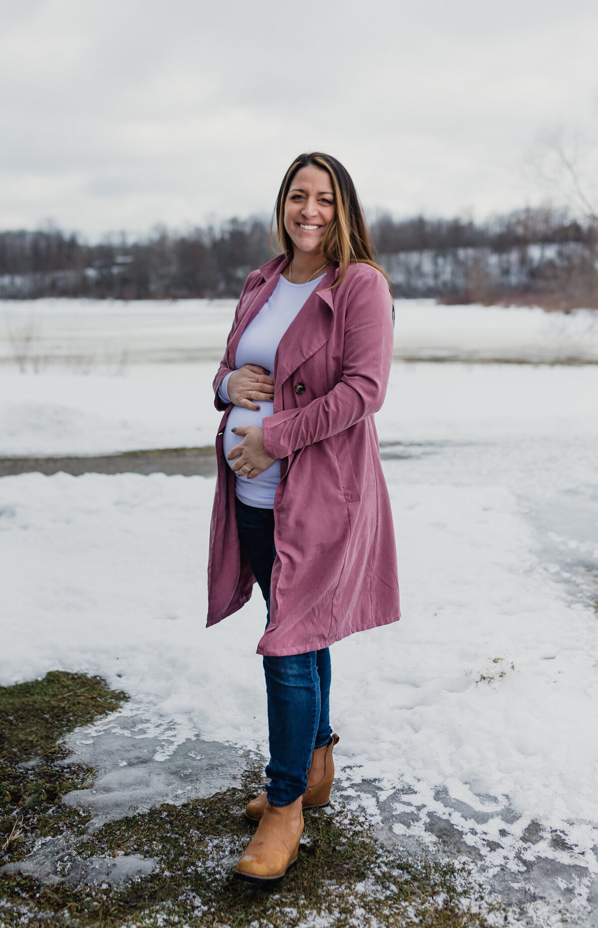 Pregnancy announcement with soon to be mom outside holding belly.