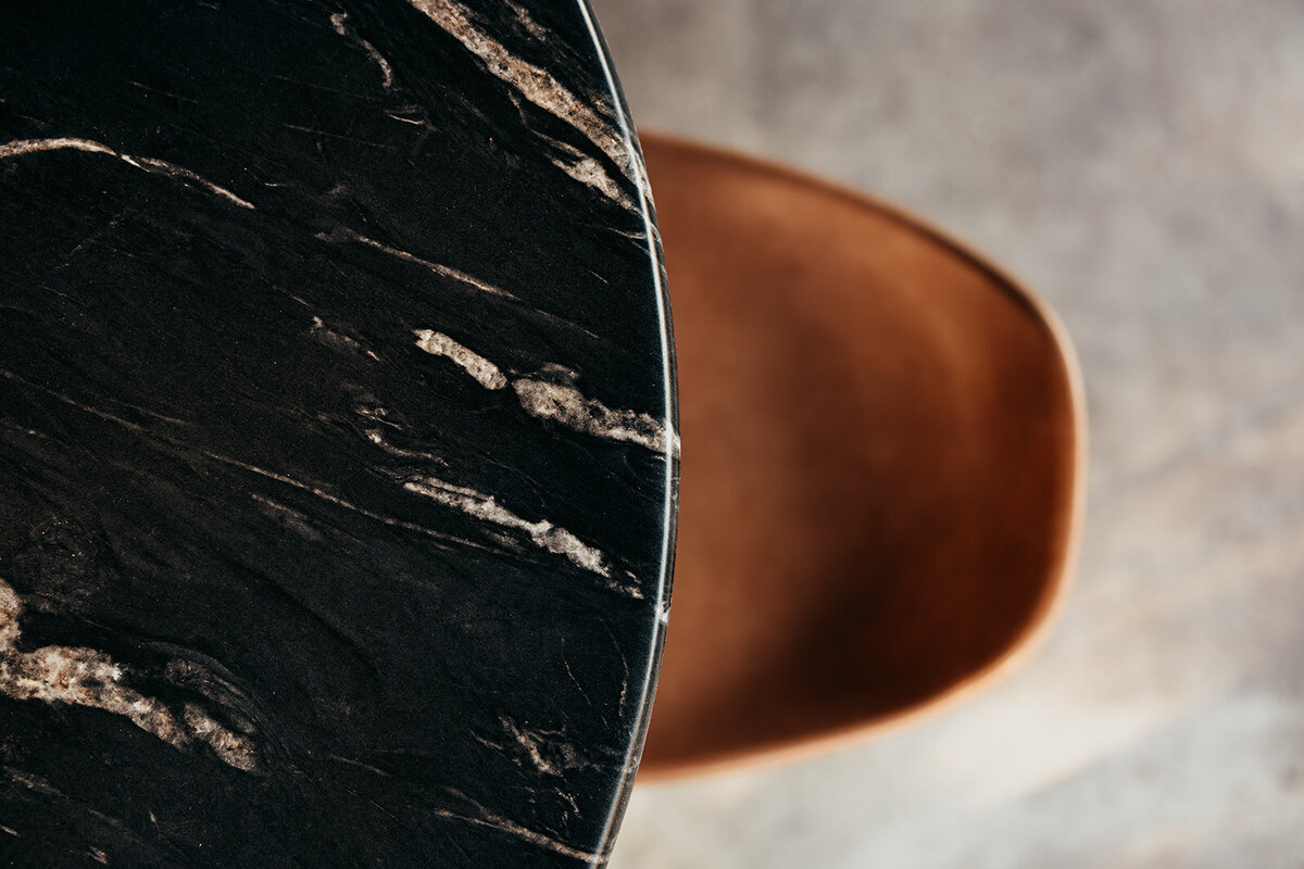 West Elm leather chair image with a marbled black cocktail table in the downstairs cocktail space at Willowbrook wedding venue