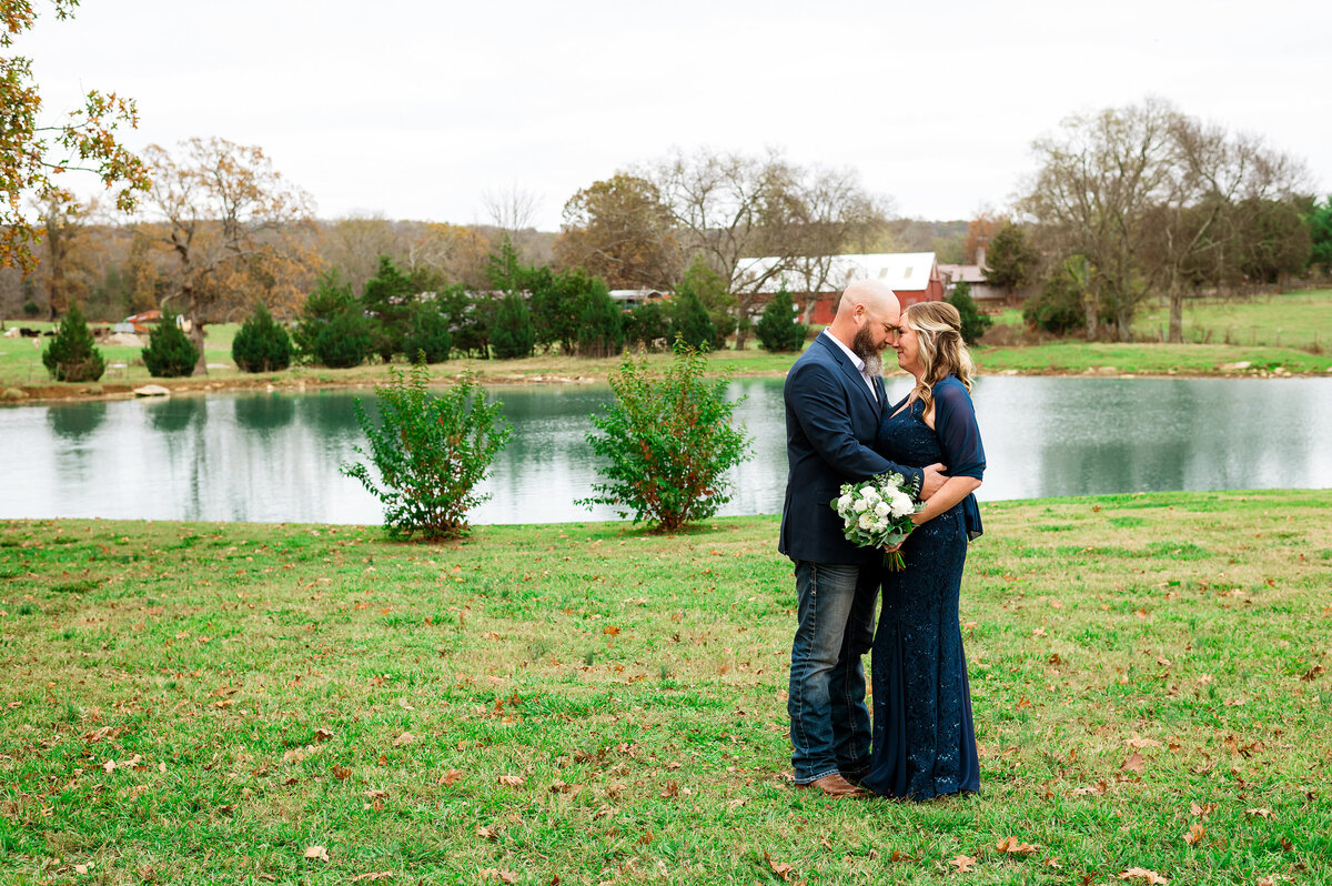 Couple sharing sweet moment beside a pond after their vows