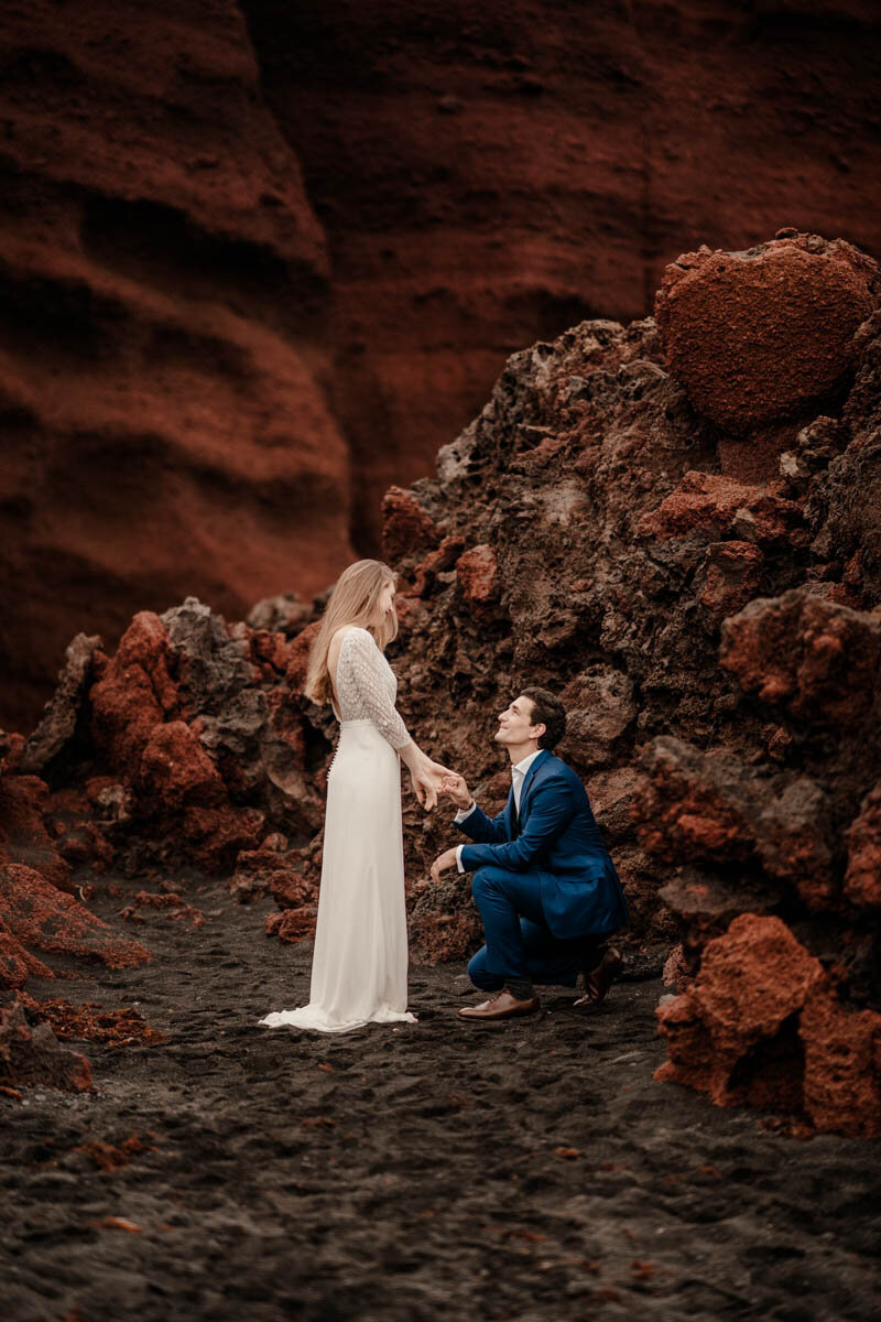 Elopement en Espagne sur la côte volcanique d’El Golfo à Lanzarote, avec un couple face à l’océan Atlantique.