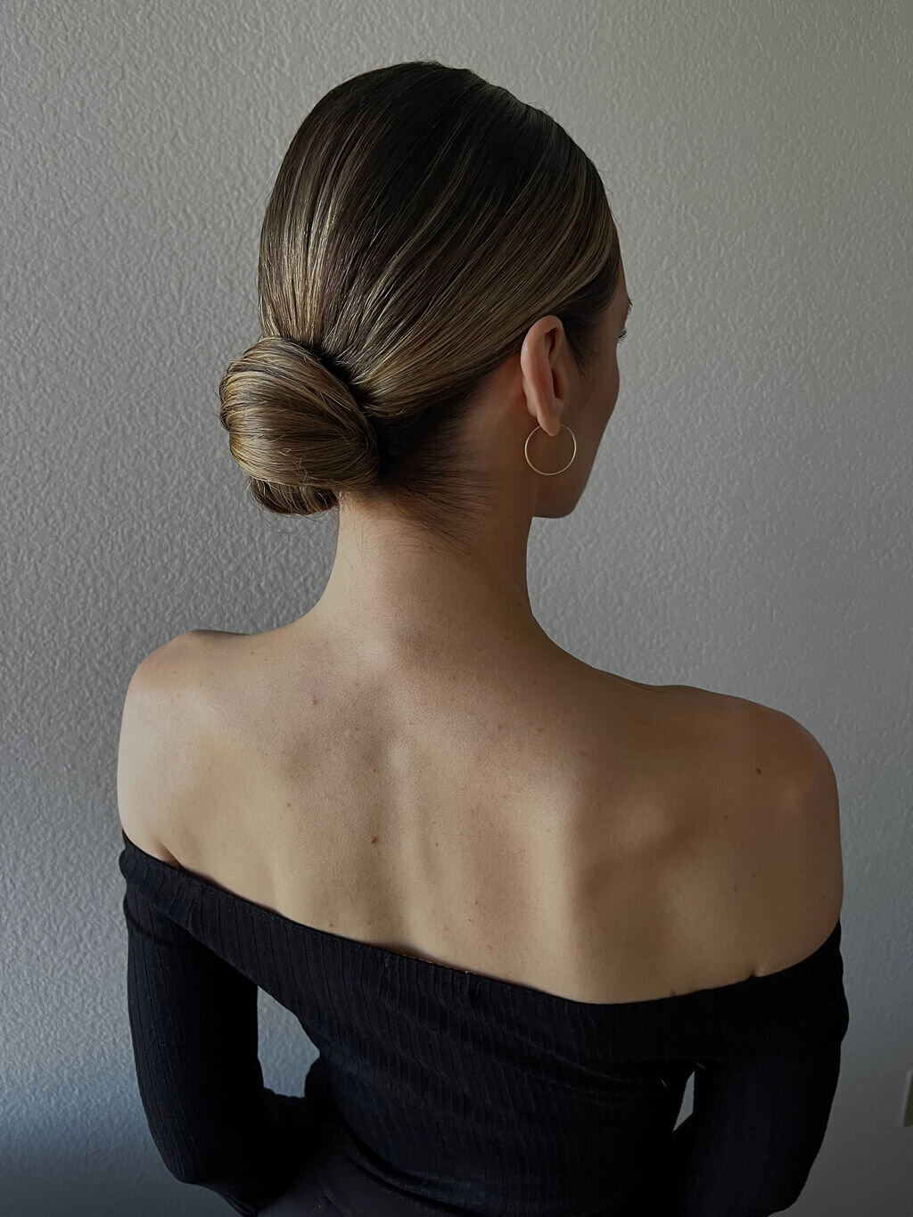 Elegant low bun and glowing soft-glam makeup on a modern bride styled by Yana’s Beauty Studio for a San Francisco wedding.