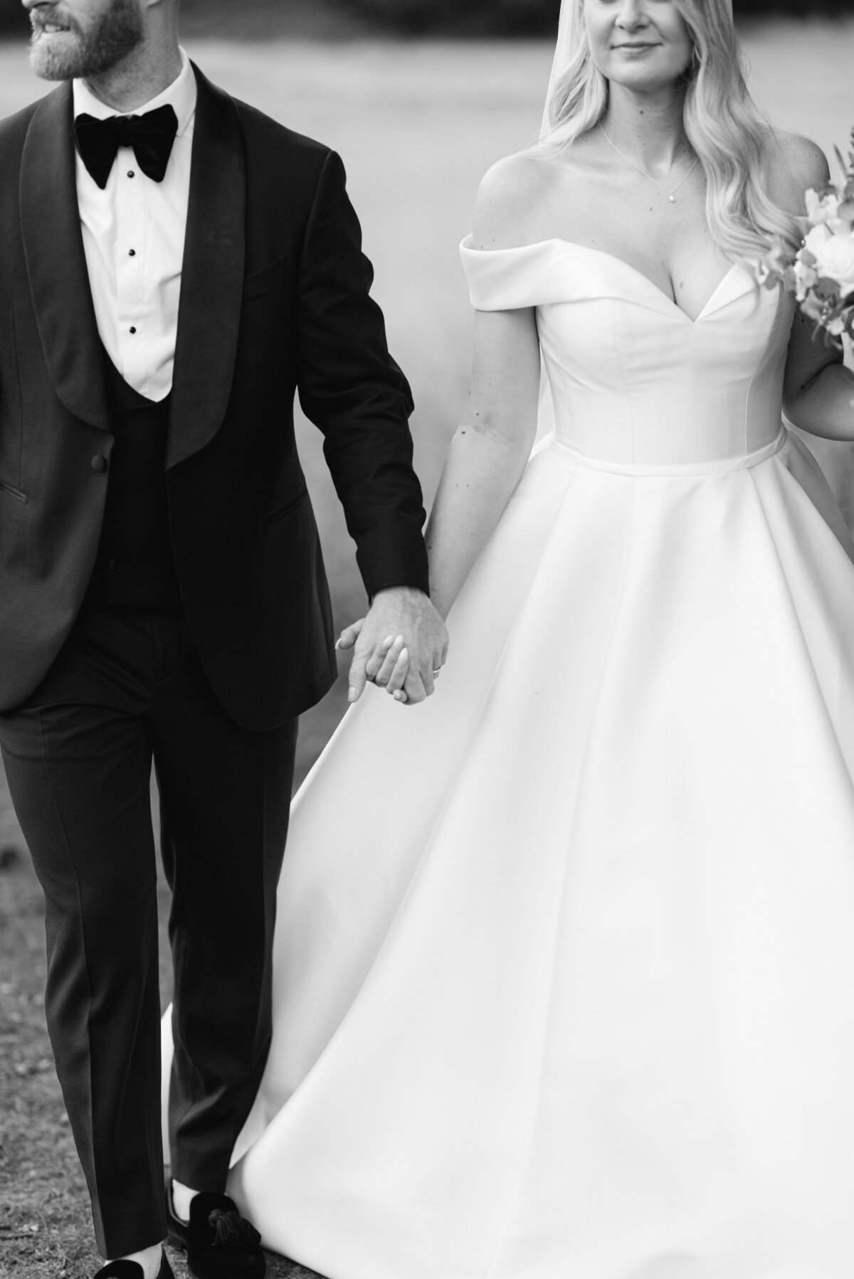 Black and white image of bride and groom walking hand in hand at botleys mansion in Surrey