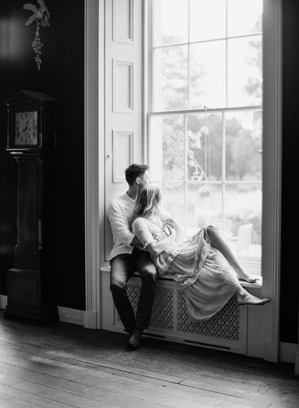 Couple cuddling on window sill in Los Angeles photographed on film