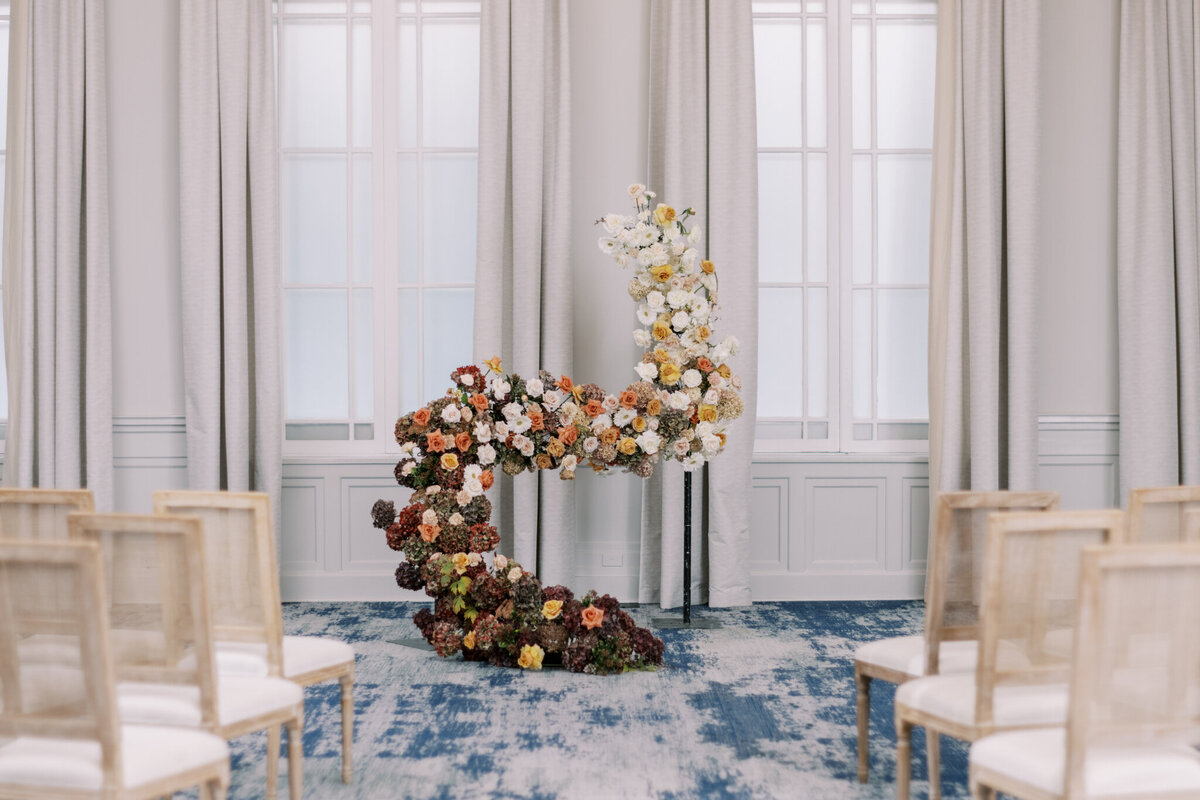 Beautiful ceremony backdrop  with nude and tangerine coloured florals at Fairmont Palliser, historical and romantic, Calgary wedding venue, featured on the Brontë Bride Vendor Guide.