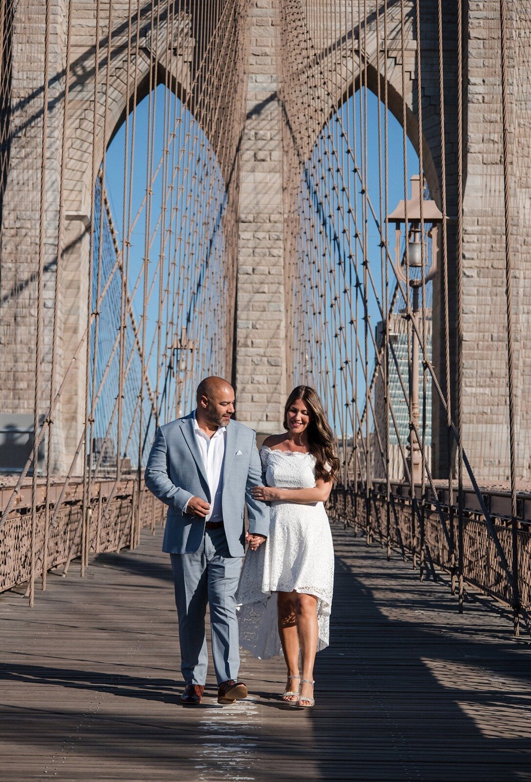 Latino couple enjoying engagement session on the Brooklyn Bridge