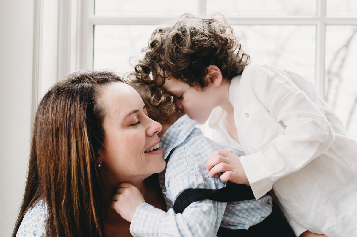 mom snuggling two boys