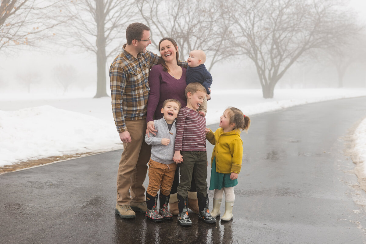 A family standing together and smiling at each other
