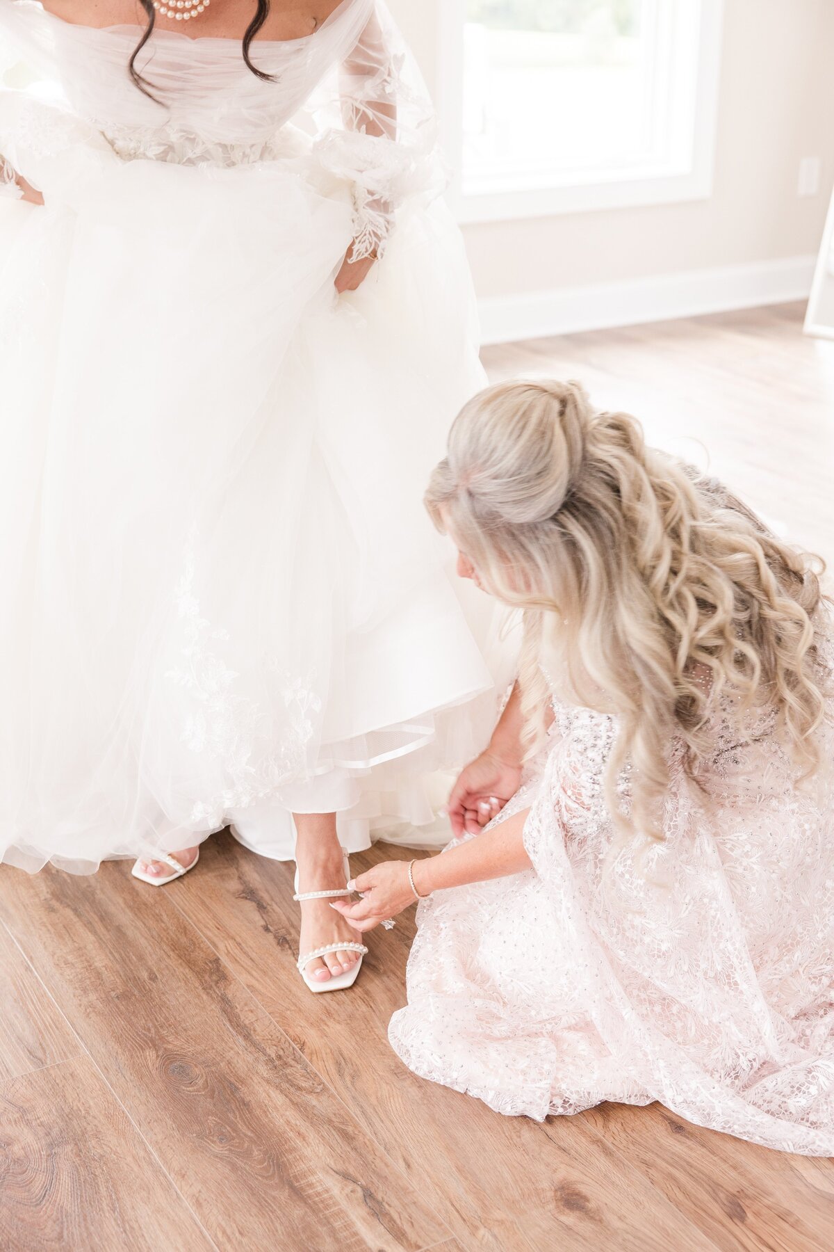 mom helping daughter on wedding day