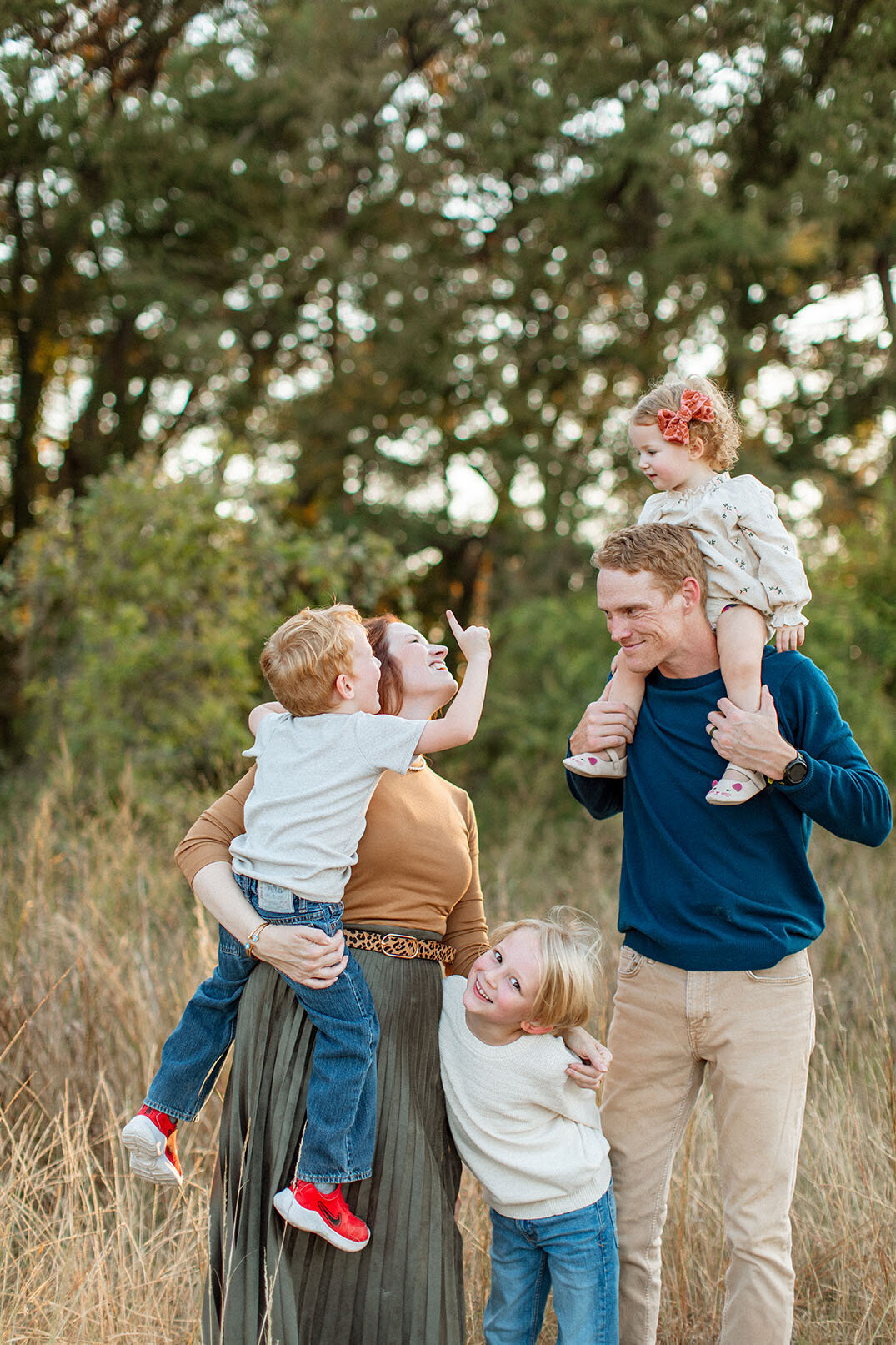 Family portrait in field with beautiful fall lighting - San Antonio photographer Sara James captures seasonal family sessions with warm golden light and autumn atmosphere in Texas outdoor locations