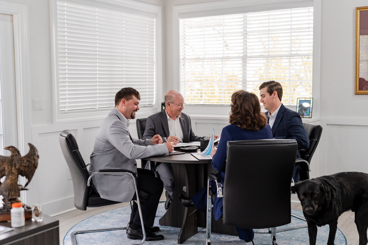 Michael J. Cox, experienced wealth manager at Coastal Bay Wealth Management in New Port Richey, Florida, meeting with his advisory team to review and strategize a client’s financial portfolio. The team provides personalized investment guidance and retirement planning services for individuals and families across the Tampa Bay area.