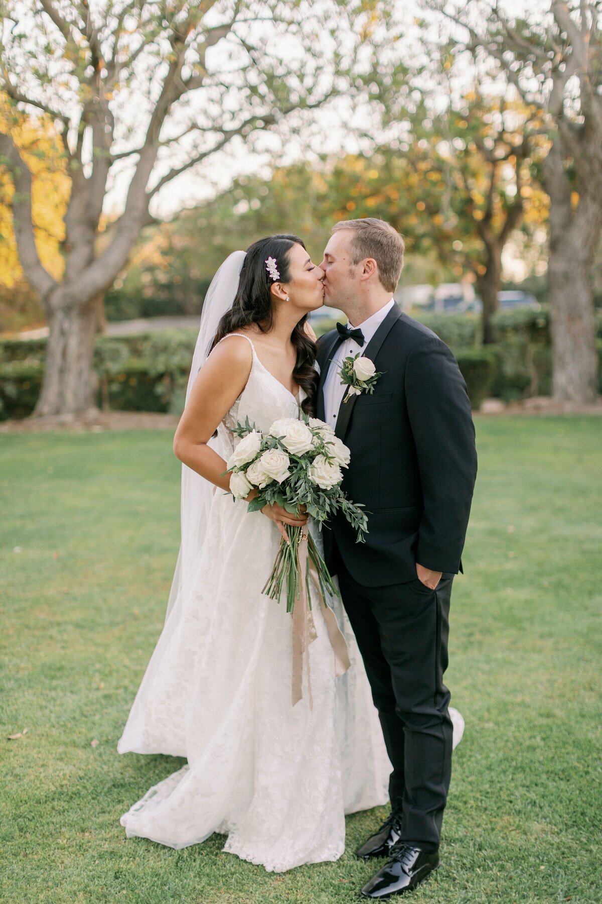 The married couple with his boutonniere and her bouquet.