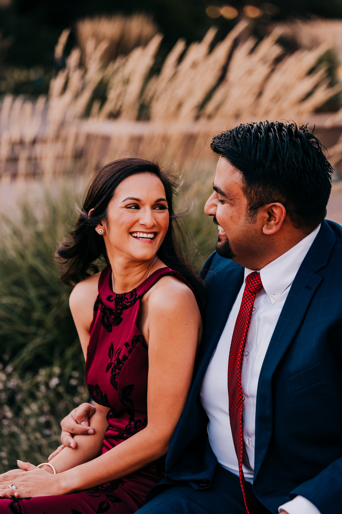 couple sitting on bench looking at each other and smiling