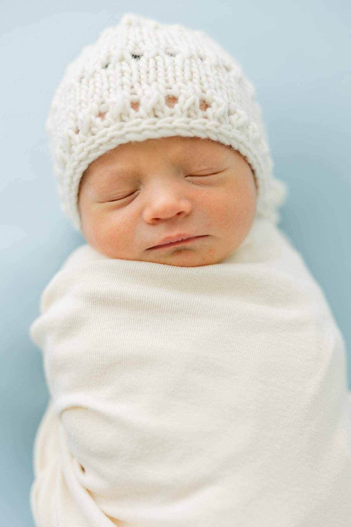 baby wears knit hat during lifestyle newborn photos erie, co