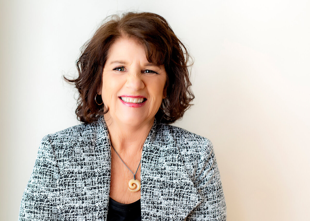 Mature female headshot client wearing a suit smiling at the camera