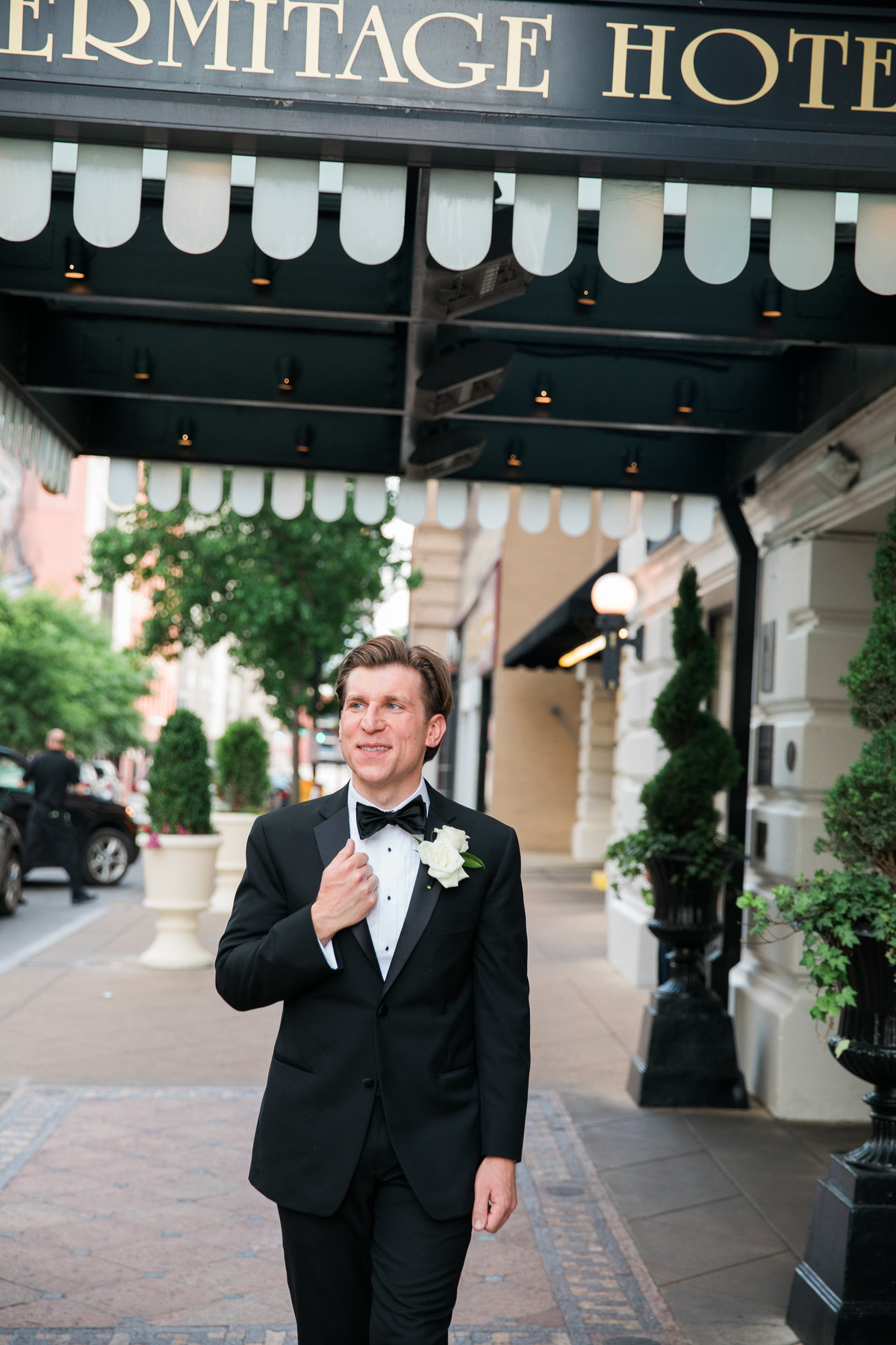 Groom standing in front of the Hermitage Hotel in Nashville.