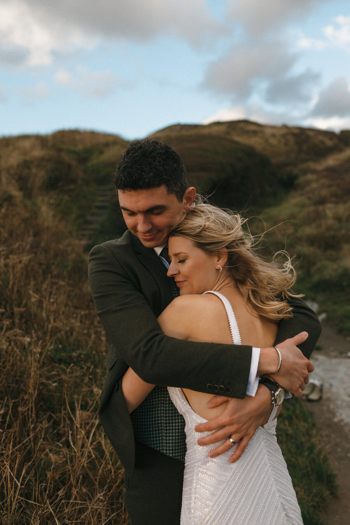 Couple embrace on cornish cliffs