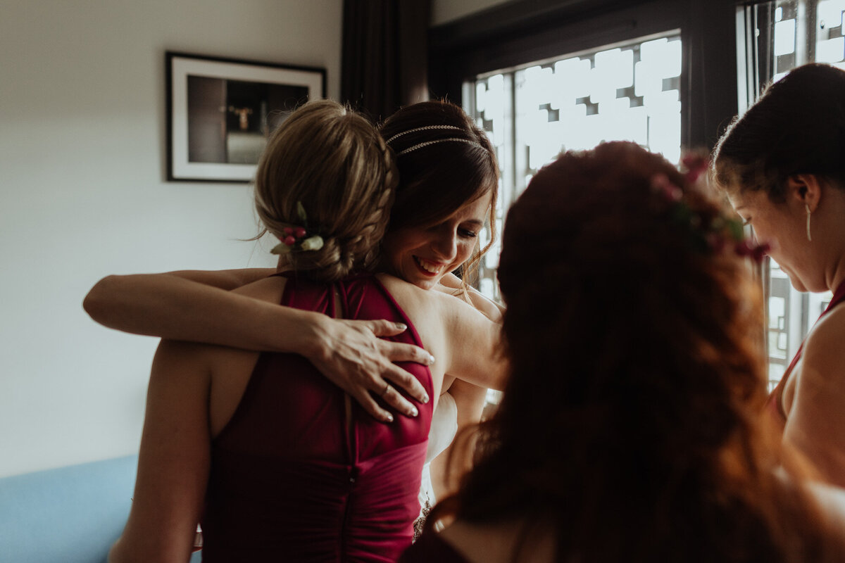 bridesmaids hugging bride