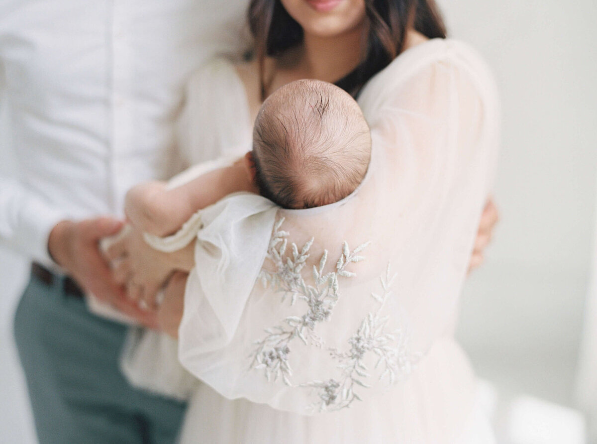 Parents cuddling their newborn during an in-home San Francisco Bay Area newborn photographer session.