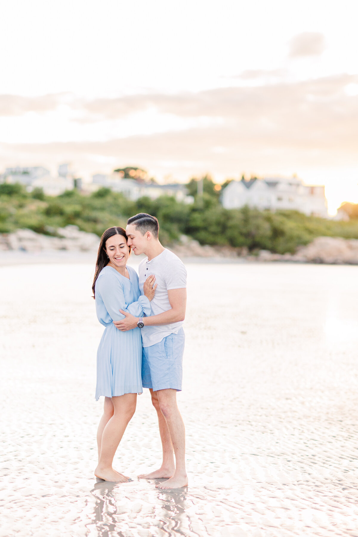 Couple snuggling at sunset representing a MA beach engagement photographer