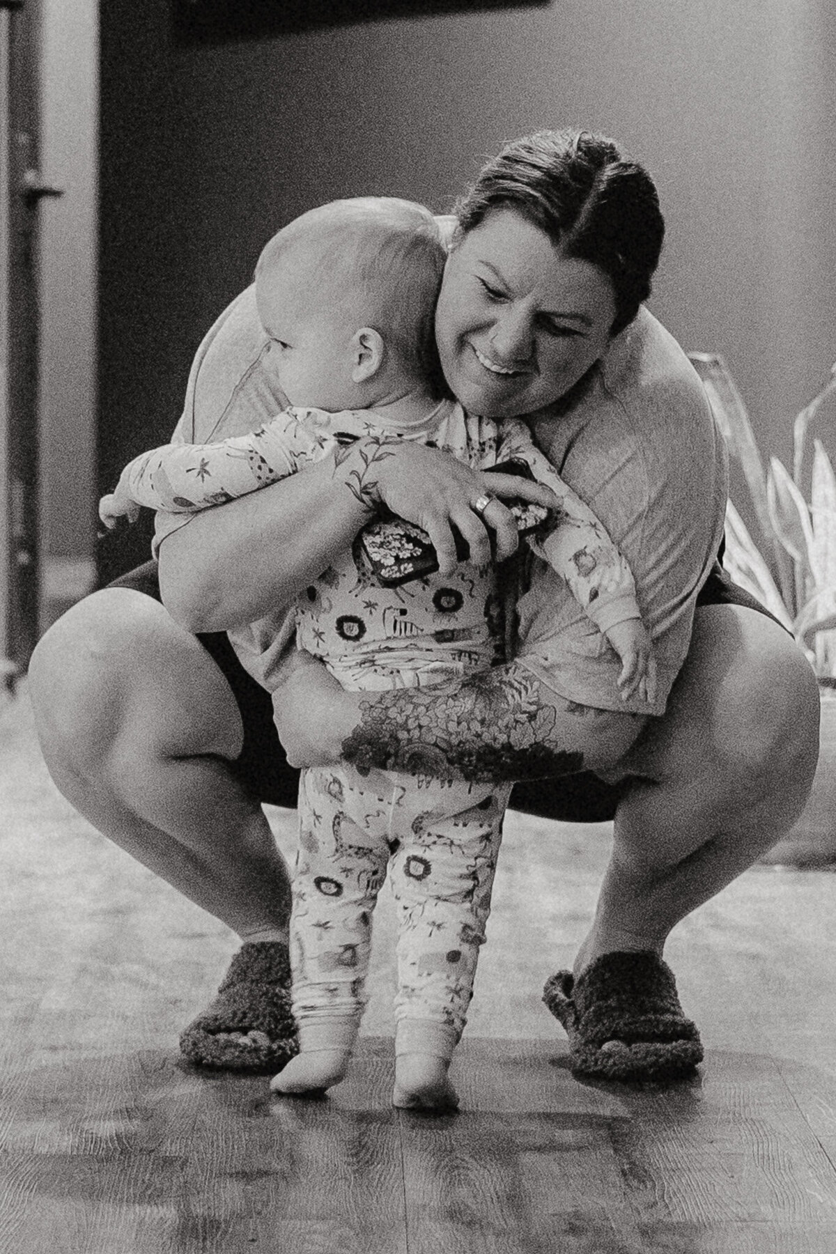 in home documentary photo of a toddler-aged son being embraced by his mother