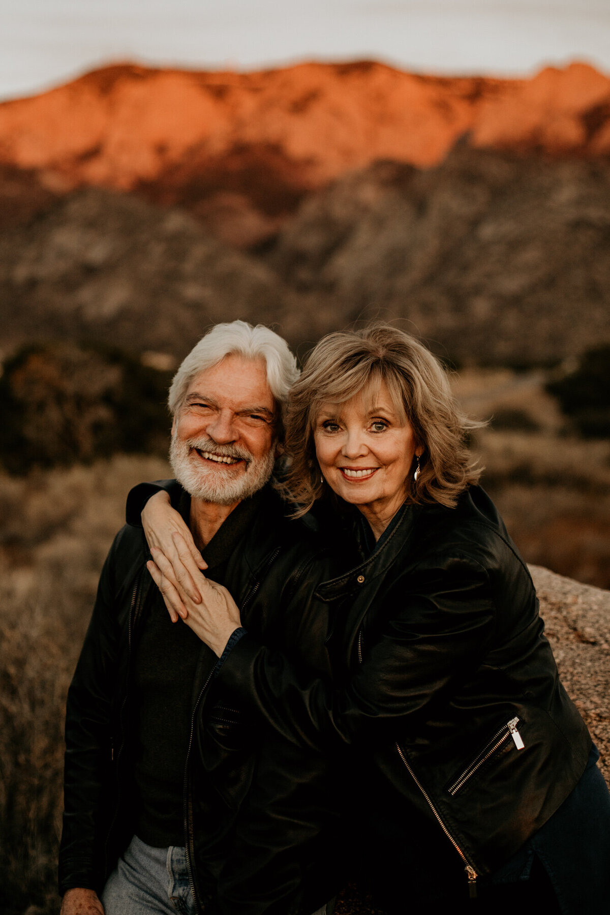 married couple looking at the camera smiling in the desert