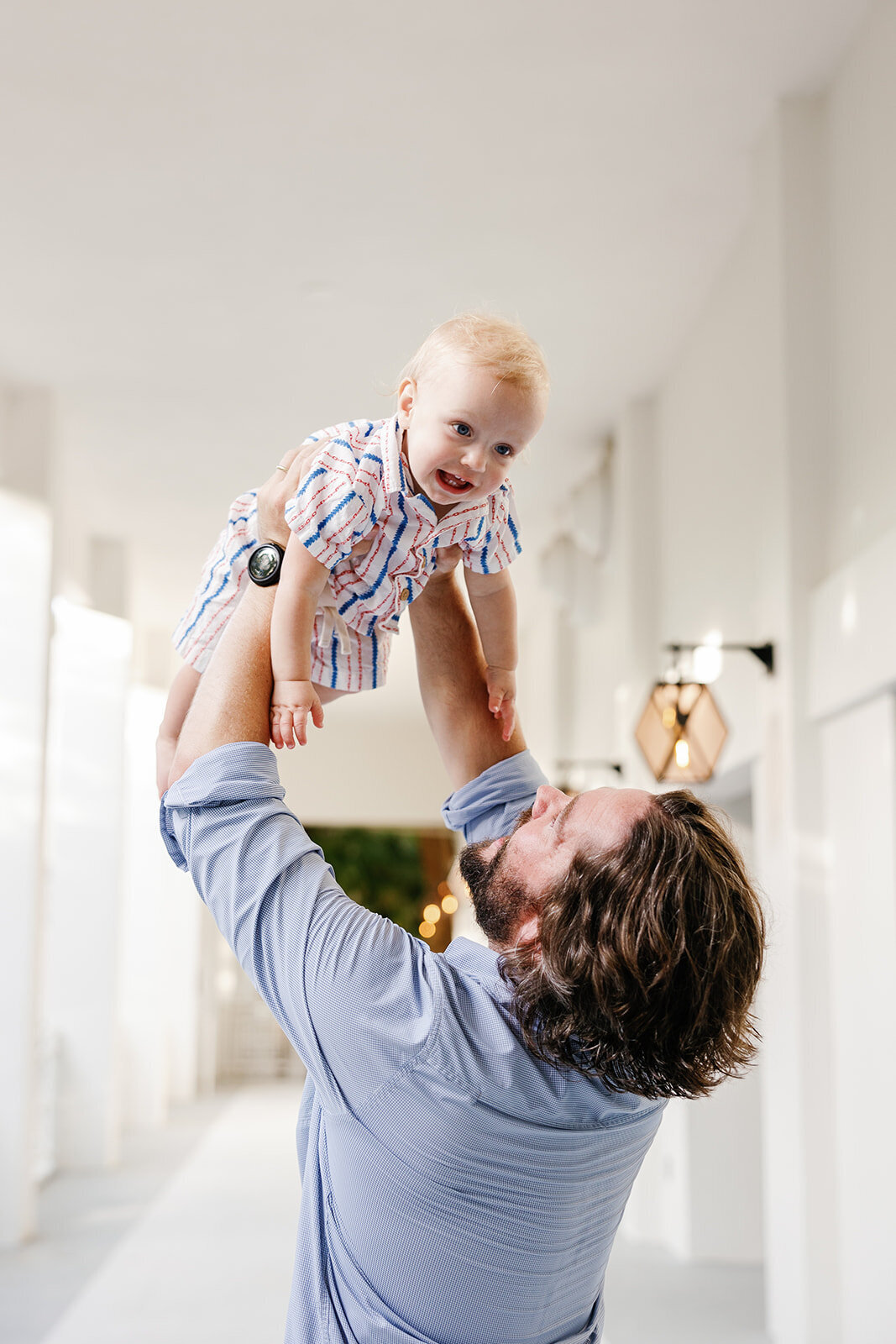 A father lifts his baby into the air during a Florida Keys family portrait session.