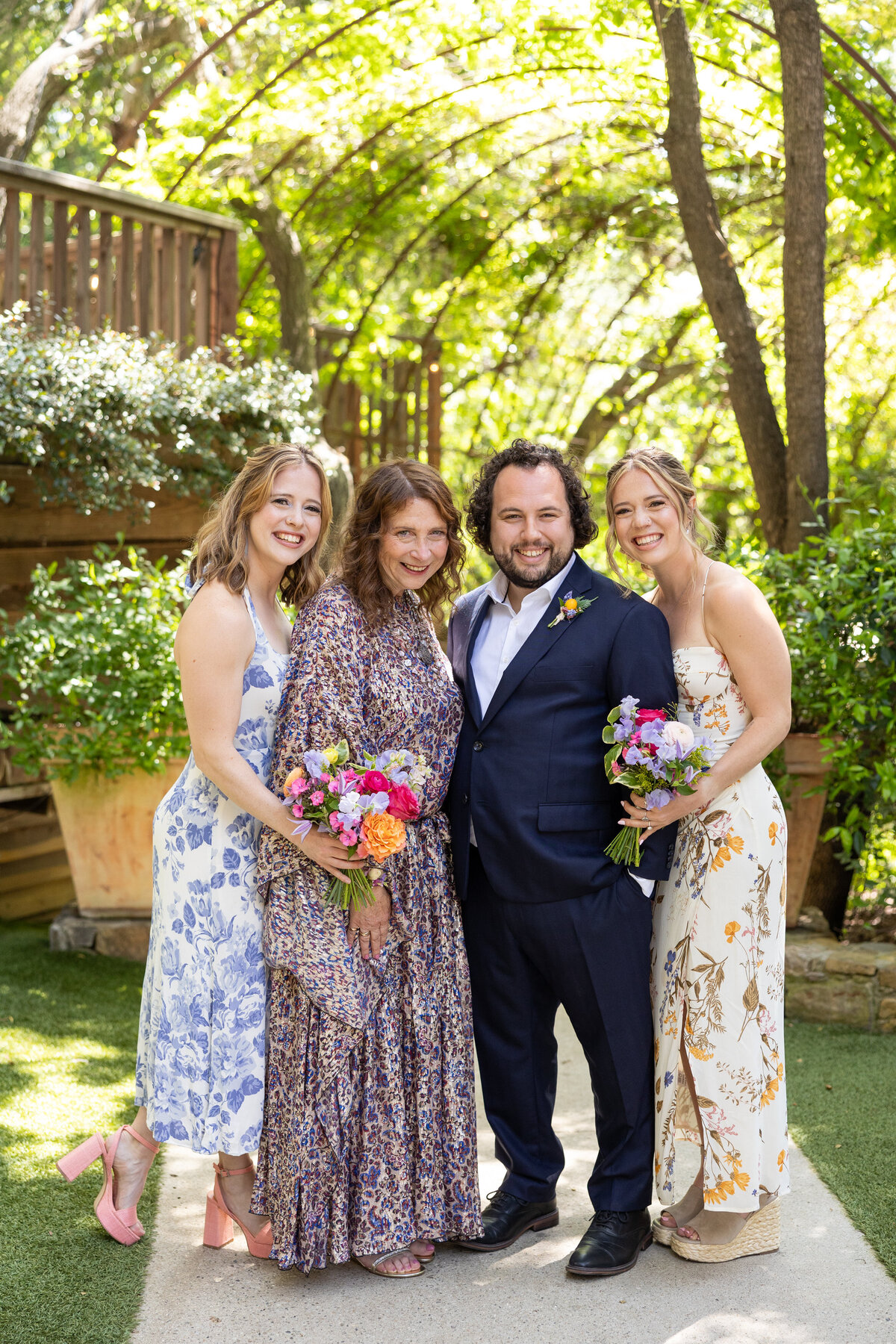 A groom smiling with wedding guests on either side of him