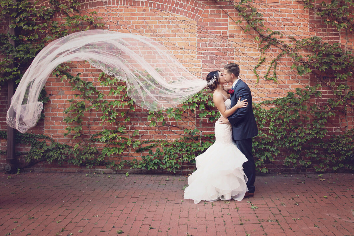 Photo of bride and groom with bride's veil blowing in the wind in downtown Erie, Pa