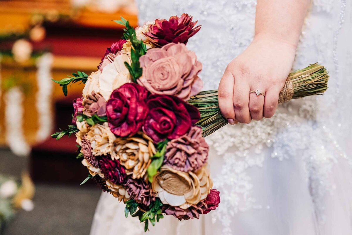 Close up of bride holding bouquet with wedding ring